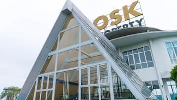 A modern building with a prominent 'OSK' sign, large windows, and a pool area.