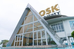 A modern building with a prominent 'OSK' sign, large windows, and a pool area. - Windmill Upon Hills By Rapi (Genting Highlands)