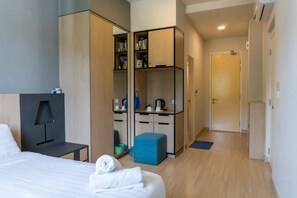 A hotel room with a bed, a desk, a wardrobe, and a mirror. - Windmill Upon Hills By Rapi (Genting Highlands)