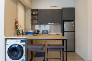 A compact kitchen with a washing machine, a toaster, and a refrigerator. - Windmill Upon Hills By Rapi (Genting Highlands)