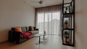 A modern living room with a sofa, coffee table, and a wall-mounted plant shelf. - Windmill Upon Hills By Rapi (Genting Highlands)
