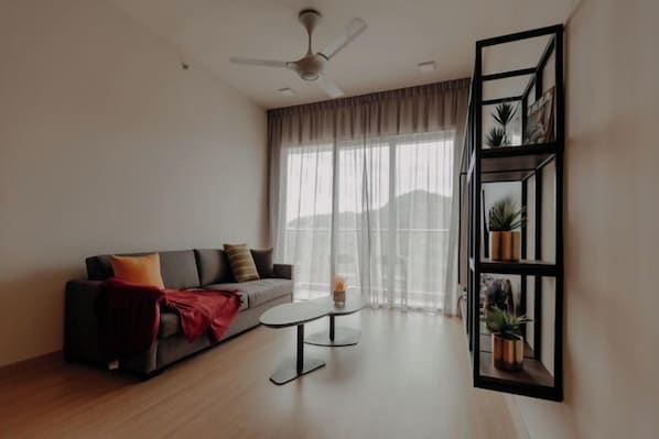 A modern living room with a sofa, coffee table, and a wall-mounted plant shelf. - Windmill Upon Hills By Rapi (Genting Highlands)
