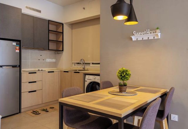A compact kitchen with modern appliances, a dining table with chairs, and a small potted plant.