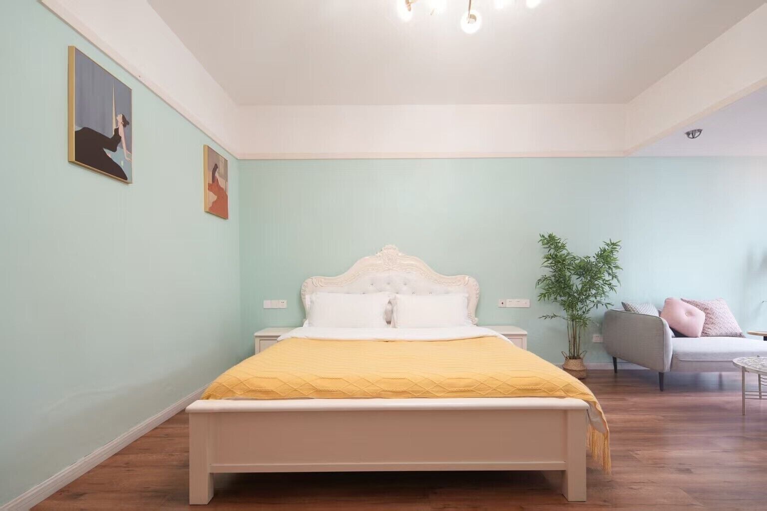 A bedroom with a bed, bedside tables, a chair, and a plant.