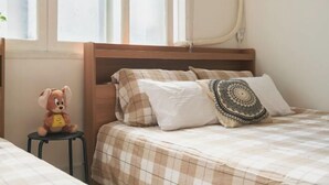 A bedroom with a bed, a nightstand, a teddy bear, and a window with blinds. - Seoul Full House/Hongdae Entrance Sta.Exit 7. Party room. Big House. Two Rooms. (Seoul)