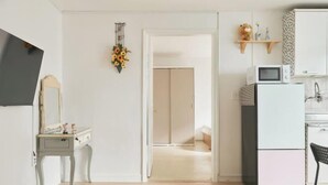 A room with a desk, a microwave, a refrigerator, and a door leading to another room. - Seoul Full House/Hongdae Entrance Sta.Exit 7. Party room. Big House. Two Rooms. (Seoul)