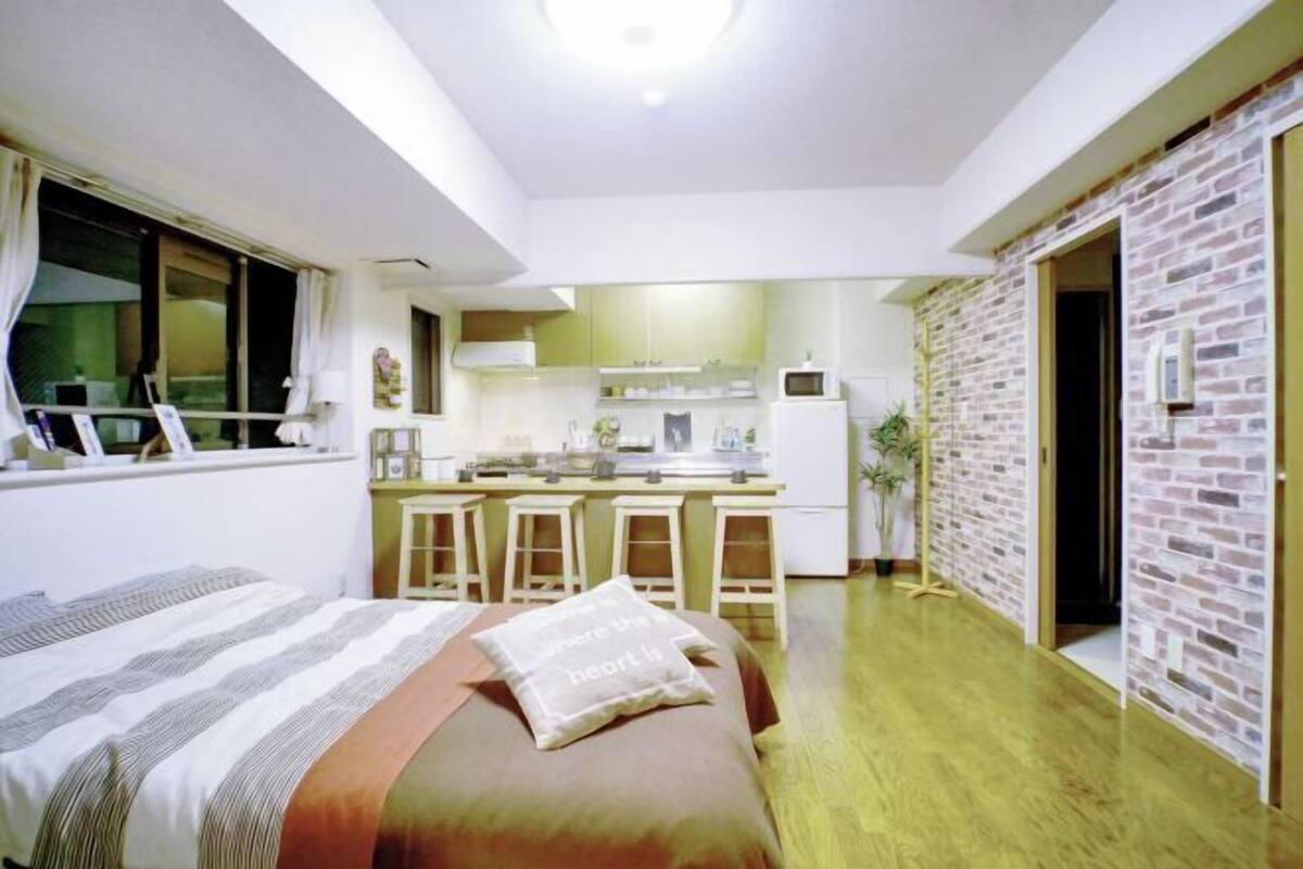 A compact room with a bed, a kitchenette, and a small dining area.