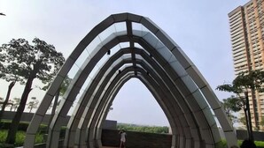 An outdoor pedestrian bridge with a modern design, featuring a wooden deck and glass panels. - Gold coast seaview pik Jakarta by SuiteStay (North Jakarta)