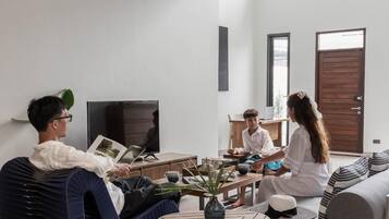 A modern living room with a sofa, a coffee table, and a television.