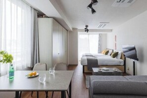 Une chambre d’hôtel moderne comprenant un coin repas, un canapé, un lit et une télévision.