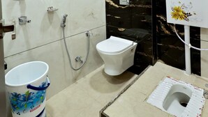 Un baño con inodoro, bidé y ducha.