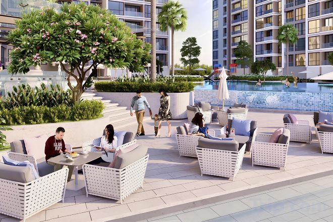 An outdoor seating area with wicker furniture, a pool, and a building with balconies.