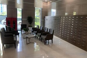 A lobby with seating, a reception desk, and a wall of mailboxes. - PQG - Vinhomes Skylake - Lavish - Resplendent Apartments in Hanoi (Hanoi)