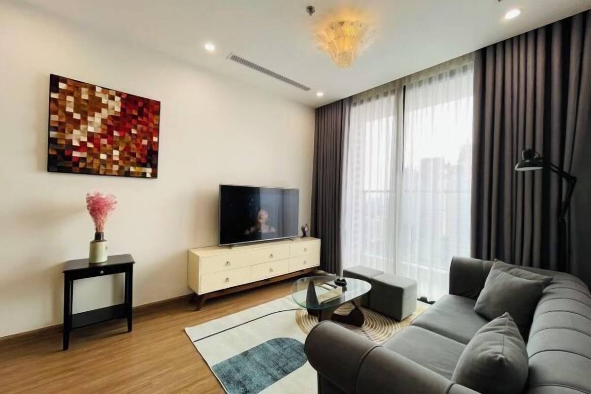 Ein modernes Wohnzimmer mit einer Couch, einem Fernseher, einem Couchtisch und einer Wanddekoration.