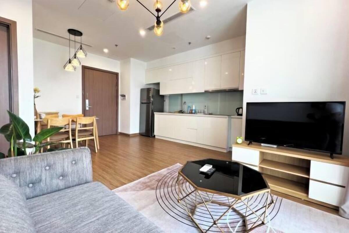 Ein modernes Wohnzimmer mit einer Couch, Couchtisch, Fernseher und Essbereich.