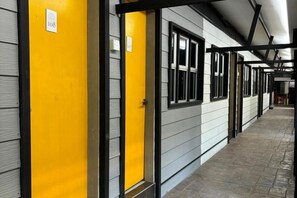 A corridor with doors, each marked with a number. - The Seven Gardens Resort & Spa (Badang)