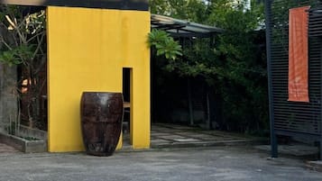 A yellow building with a large planter in front.