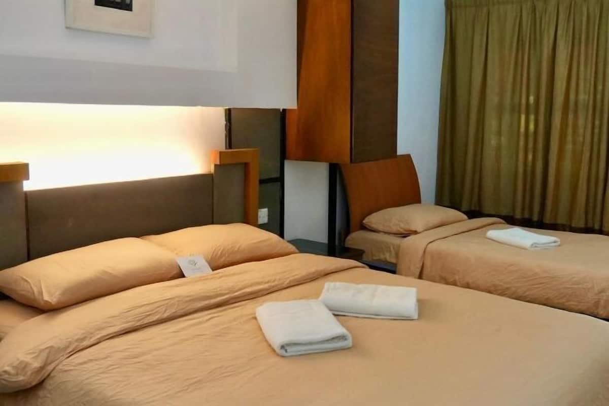 Une chambre d’hôtel avec deux lits, chacun doté d’une tête de lit, d’une table de chevet et d’une lampe.