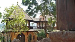 A traditional building with a brick facade, arched windows, and a tiled roof. - Chateau Orientale (Luang Prabang)