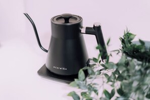 A black electric kettle on a black coaster with a visible brand name. - Minimalist Loft 8: Namba Compact Studio & 24/7 Gym (Osaka)