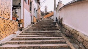 A set of stone steps leading up a narrow alleyway between buildings. - Minimalist Loft 8: Namba Compact Studio & 24/7 Gym (Osaka)