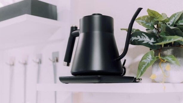 A black electric kettle on a white shelf with a potted plant beside it. - Minimalist Loft 8: Namba Compact Studio & 24/7 Gym (Osaka)