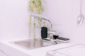 A modern kitchen with a stainless steel sink, a faucet, and a soap dispenser. - Minimalist Loft 8: Namba Compact Studio & 24/7 Gym (Osaka)