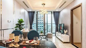 A modern dining area with a marble table, chairs, and a city view. - Condotel Imperial Landmark 81 (Ho Chi Minh City)