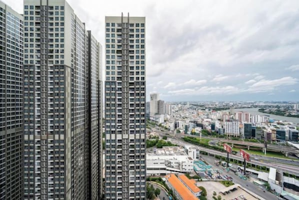 A high-rise building with a view of a cityscape, including a river and other buildings.