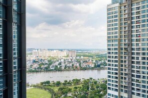 A high-rise building with a view of a river and a cityscape in the background. - Condotel Imperial Landmark 81 (Ho Chi Minh City)