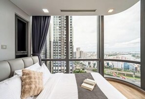 Une chambre d’hôtel moderne avec un grand lit, une vue sur la ville et une fenêtre avec des rideaux.