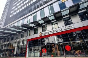 A modern building with a storefront featuring a red awning and signage for 'BEANS & CREAM' and 'PENGUYDUNINGS.' - Tropicana 218 With Sea View by LS Staycation (George Town)