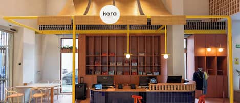 A modern interior with a central counter, seating area, and a visible logo.
