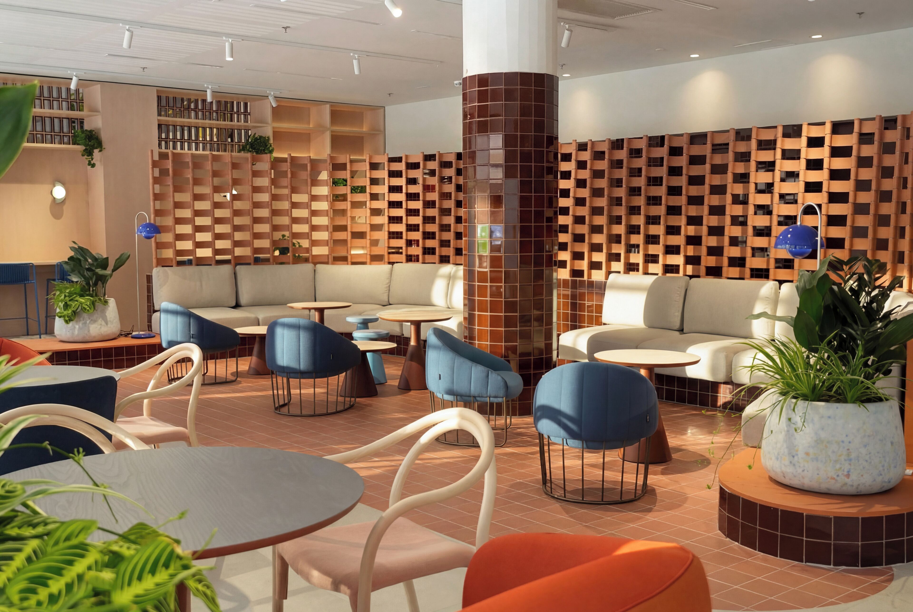 A modern lounge area with seating, tables, and a decorative wall.