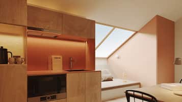 Une cuisine moderne avec des meubles en bois, un four encastré et une lucarne.