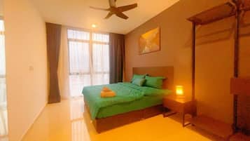 A bedroom with a bed, a ceiling fan, a nightstand with a lamp, and a window with curtains.