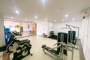 Et fitnesscenter med træningsudstyr, reception og venteområde.