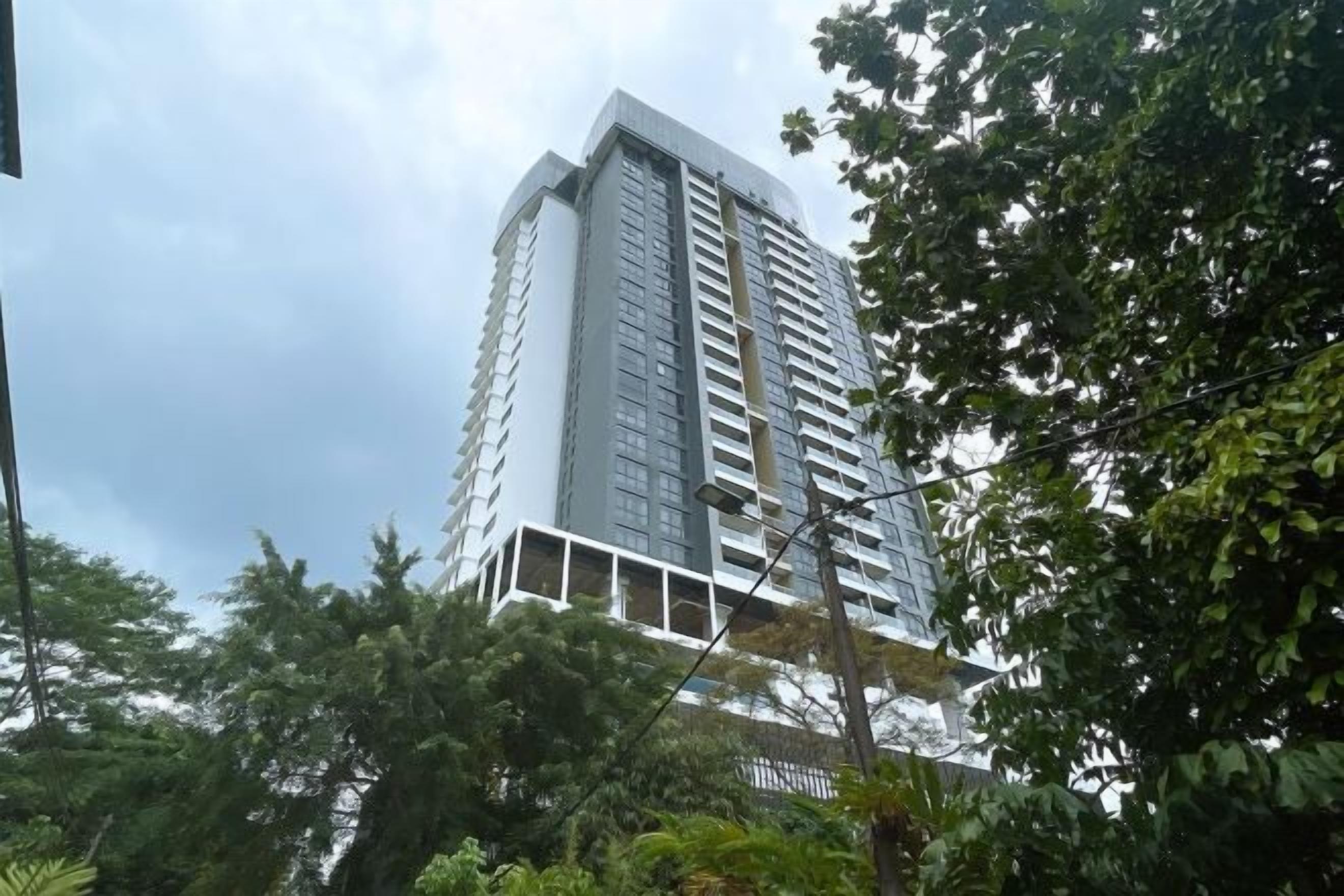 A tall, modern building with a white facade and multiple balconies.