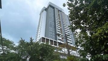 A tall, modern building with a white facade and multiple balconies.