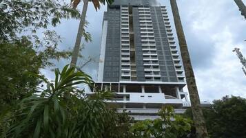 A tall building with multiple floors, surrounded by greenery.