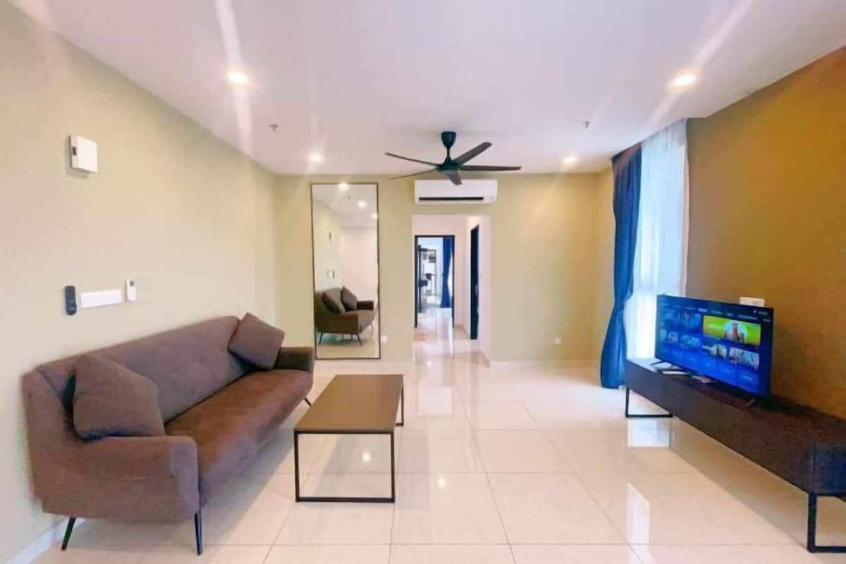 Un salon moderne avec un canapé, une table basse, un téléviseur et un ventilateur de plafond.