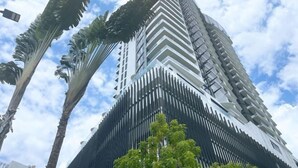 A tall, modern building with a distinctive zigzag pattern and balconies. - GYDEN STAYCATION #The Straits Johor Bahru (Johor Bahru)