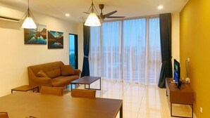 A modern living room with a sofa, a dining table, and a TV. - GYDEN STAYCATION #The Straits Johor Bahru (Johor Bahru)