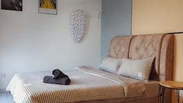 A bedroom with a bed, a small round table, and a wall-mounted decorative piece.