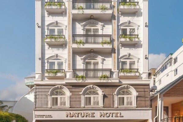 A multi-story hotel with balconies, arched windows, and a sign reading 'NATURE HOTEL'. - Nature Hotel - Le Dai Hanh (Dalat)