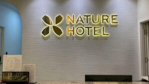 A reception desk with a sign that reads 'NATURE HOTEL' and a reception area. - Nature Hotel - Le Dai Hanh (Dalat)