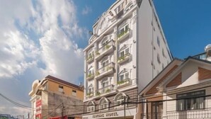 A multi-story hotel with balconies, a sign reading "NATURE HOTEL," and a clear blue sky in the background. - Nature Hotel - Le Dai Hanh (Dalat)