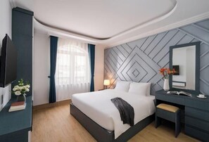 Une chambre d’hôtel moderne, dotée d’un grand lit, d’un bureau, d’une télévision et d’un mur décoratif.