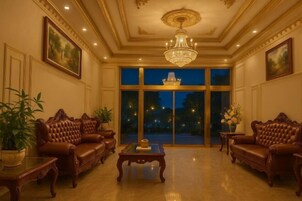 Una habitación amplia con un gran ventanal, un candelabro y sofás de cuero.