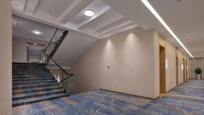 A hotel hallway with a carpeted floor, a staircase, and a ceiling with recessed lighting. - XIAN HOTEL (The Grand Hotel) (Bac Ninh)